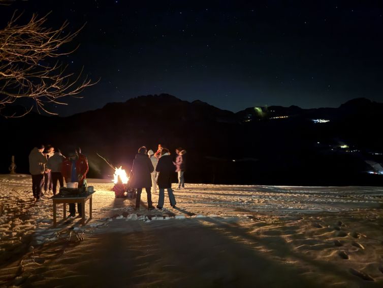 Gäste an Silvester am Lagerfeuer mit Blick zum Nassfeld